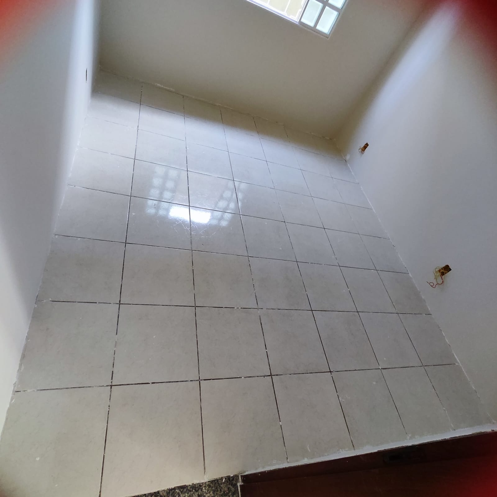 Corredor com piso cerâmico antigo e desgastado, antes da reforma