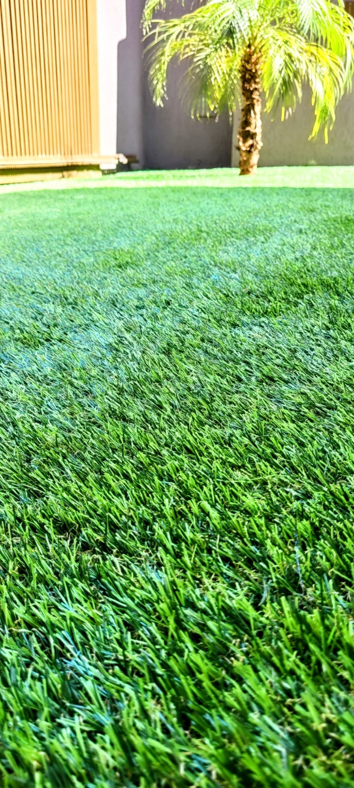 Grama sintética em jardim com acabamento junto ao piso