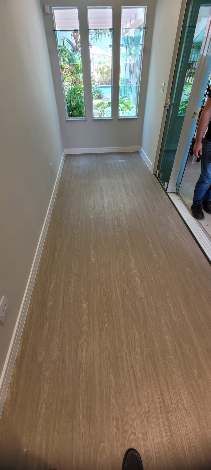 Piso laminado instalado em corredor com pessoa ao fundo
