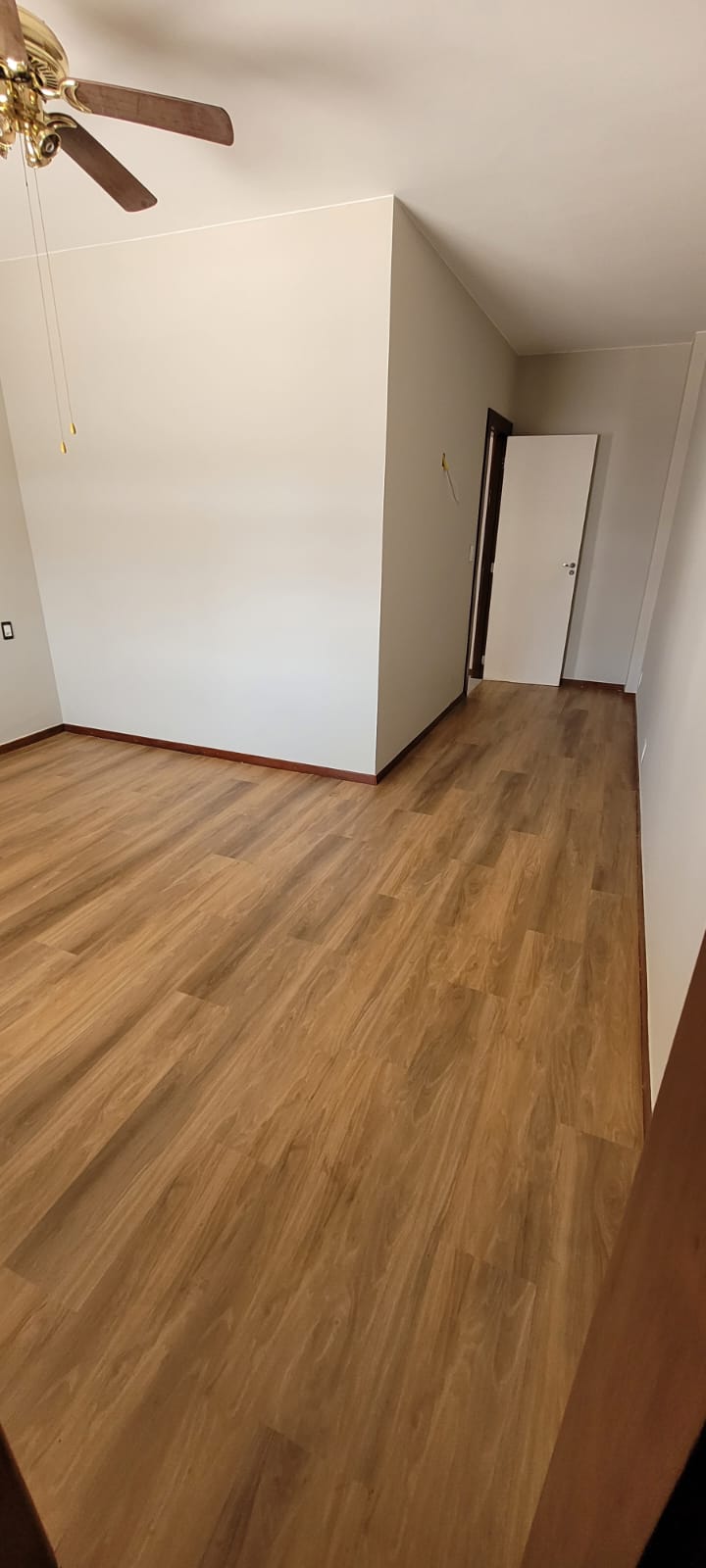 Piso laminado instalado em quarto amplo com luz natural